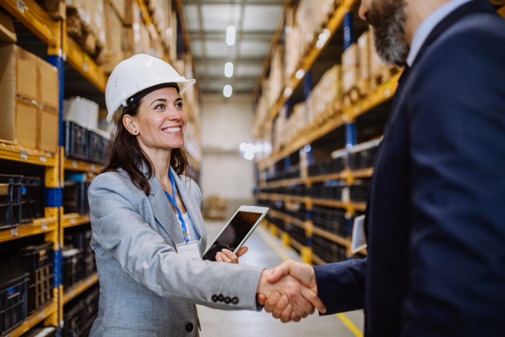 Two people shaking hands in a warehouse