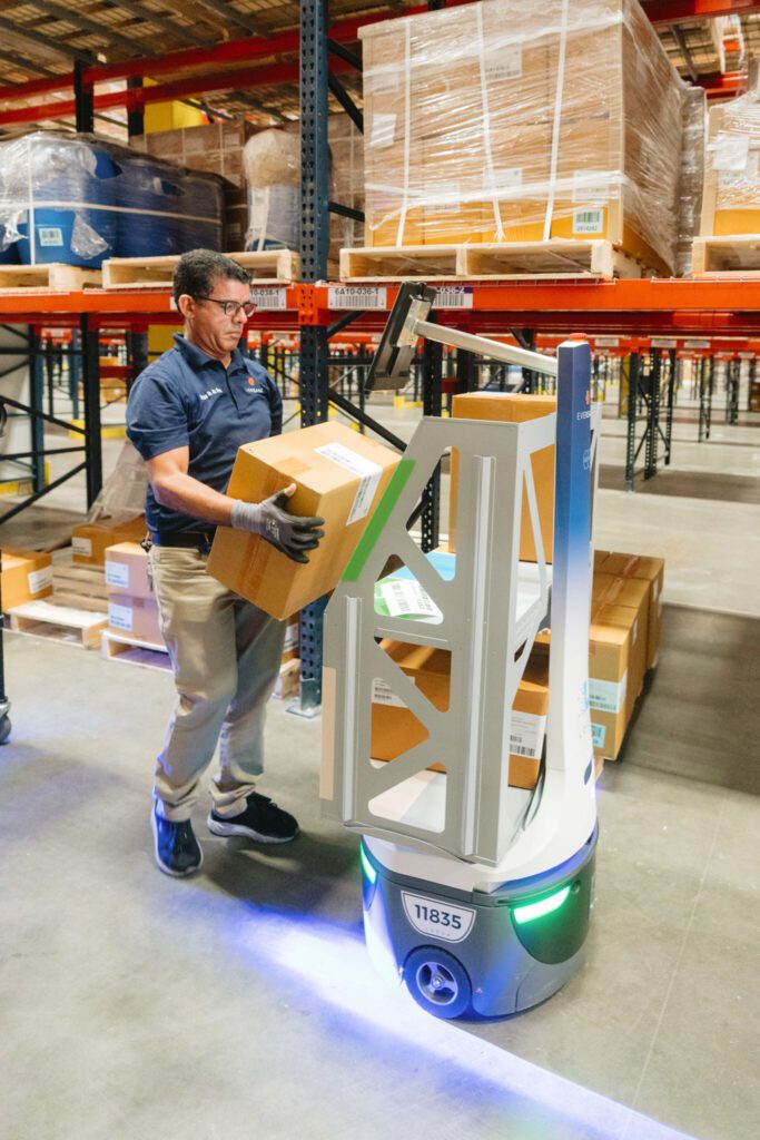 Man placing a box on a robot