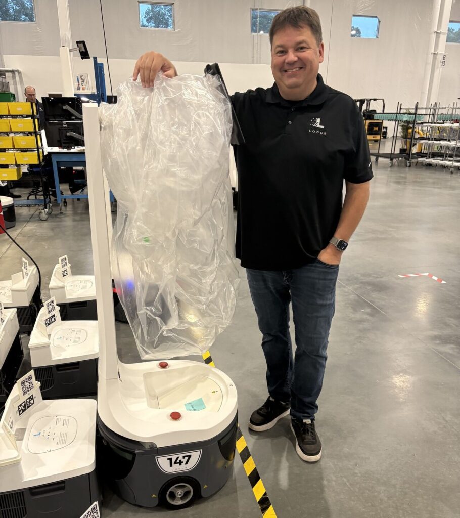 A man and a Locus Origin robot in a warehouse