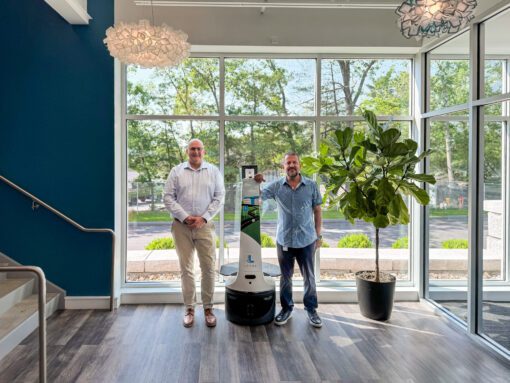 Tracy, Origin, and Fouad standing in the headquarters lobby
