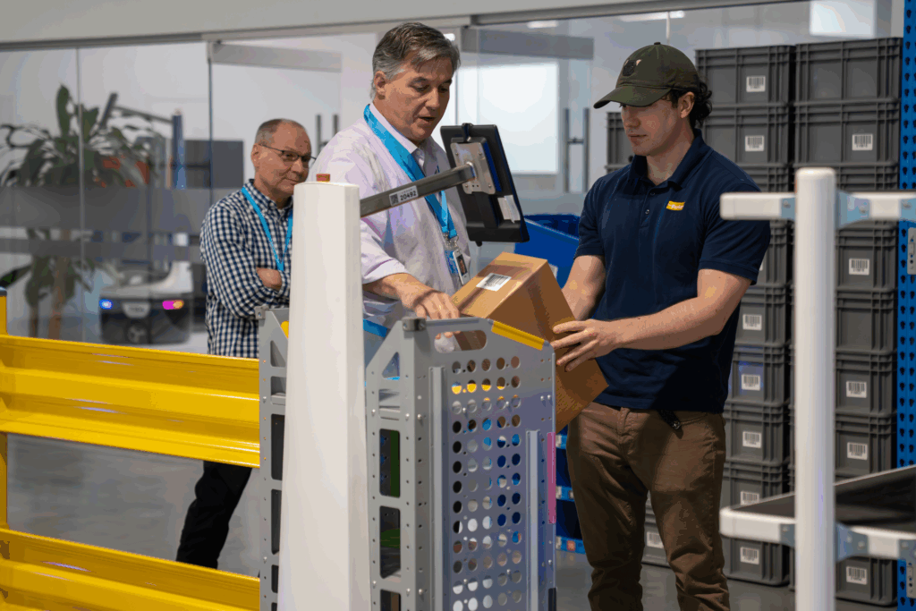 Three men working in a warehouse on a Locus Origin bot